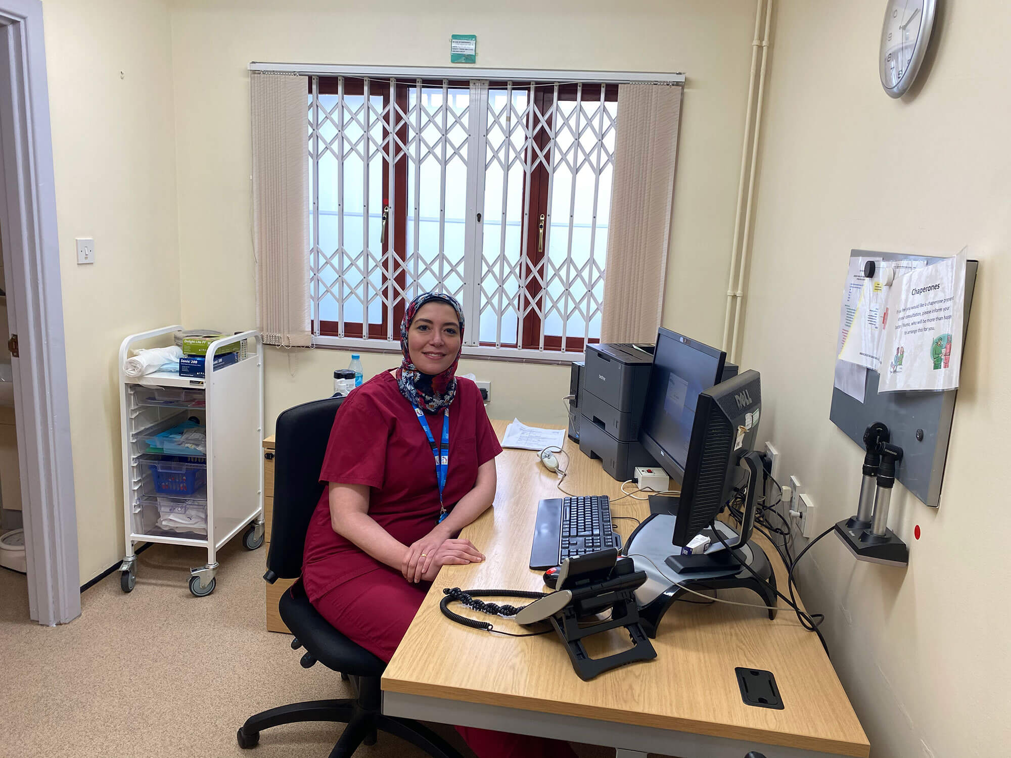 Moorcroft Medical Centre team member sat at a desk smiling at the camera